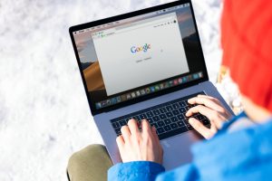 Person researching privacy act changes (possibly Google) on a laptop in the snow.
