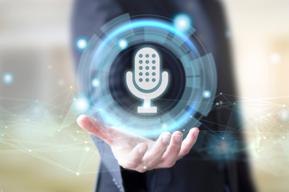 A man in a suit holds a holographic image of a microphone, symbolizing voice search optimisation. The background is composed of abstract, digital network elements, emphasizing technological advancement in voice search technology.