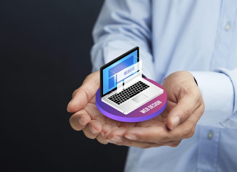 Hands holding a laptop displaying web design, illustrating the concept of designing graphics for websites in minimalist style.