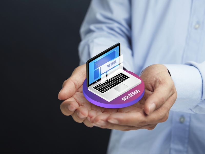 Hands holding a laptop displaying web design, illustrating the concept of designing graphics for websites in minimalist style.