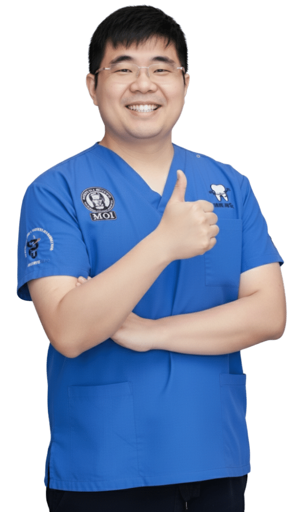 Dentist in blue scrubs smiling and giving a thumbs up