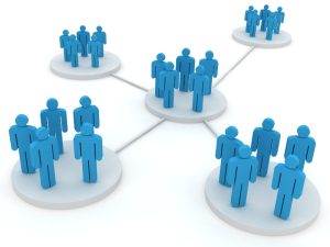 Small business and social media network concept with groups of blue figures connected on a white background.