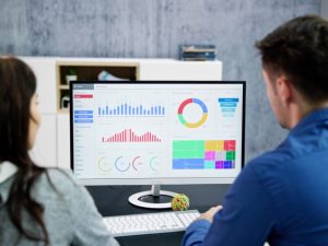 Two people analysing website analytics data, discussing how to make your website show on Google.