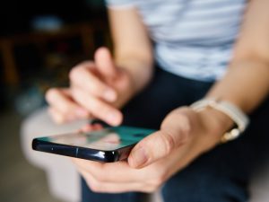 Person using a smartphone, illustrating mobile optimisation for a custom home builders website.