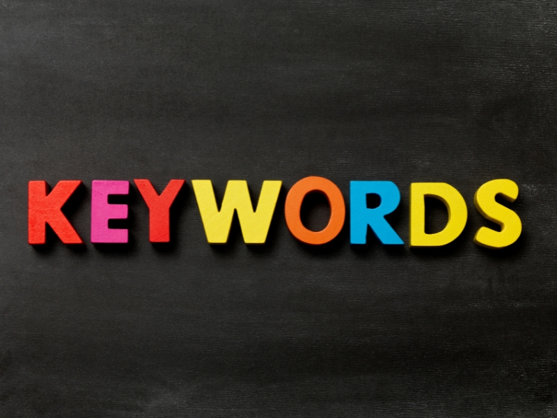 Colourful keywords text on a blackboard symbolising the importance of strategic Google Ads keywords selection for ad success.