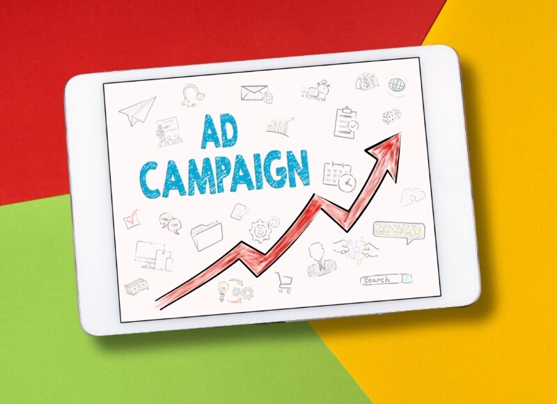 Tablet displaying types of Google Ads campaigns with upward graph, showcasing growth and success for businesses through ad strategies.
