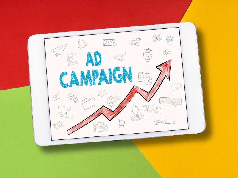 Tablet displaying types of Google Ads campaigns with upward graph, showcasing growth and success for businesses through ad strategies.