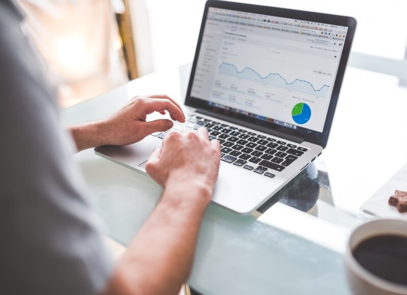 A person analysing website traffic and ad relevance data on a laptop, optimising Google Ads performance for better rankings.