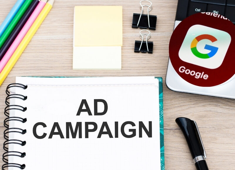Google Ads campaign success: Notebook, pencils, and Google logo.