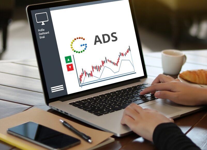 Laptop screen showing "ADS" and a graph, illustrating how to improve underperforming Google Ads.