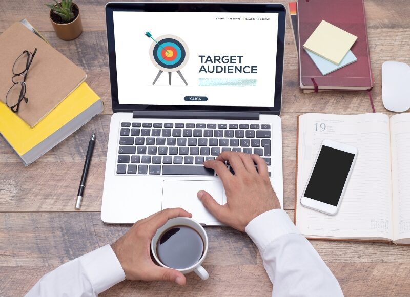 A person works on a laptop displaying "Target Audience", aiming to improve ad targeting accuracy.
