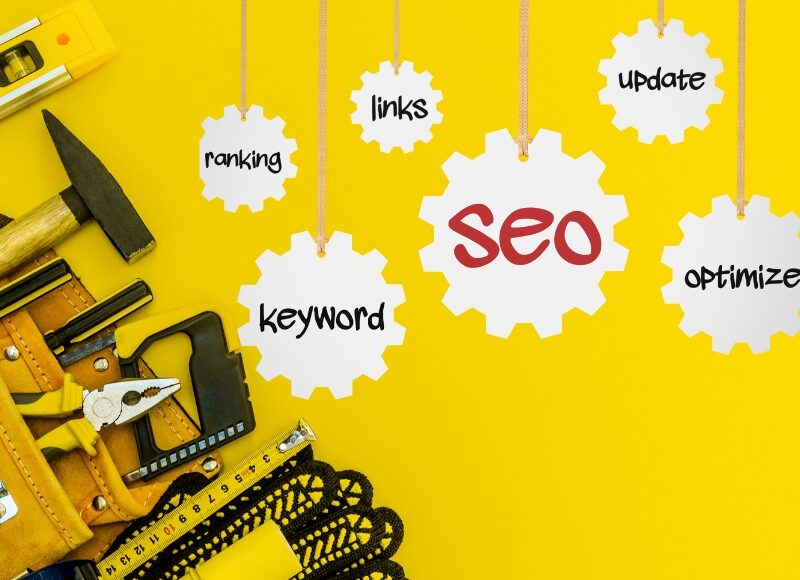 seo for local builders concept with tools, gears and keywords on yellow background.