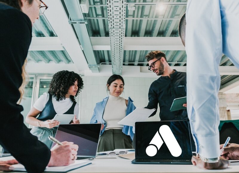 Team collaborating on digital strategy with laptops displaying Google Ads logo, planning effective google advertising services