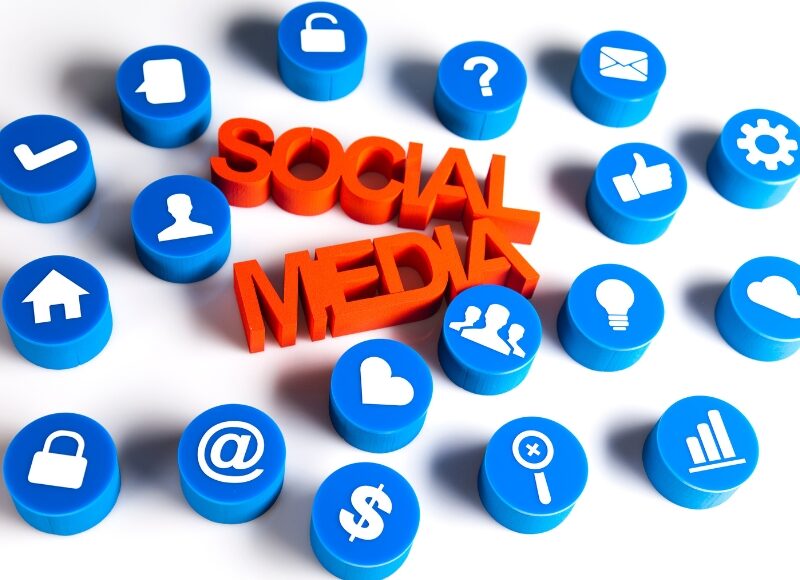 Social media marketing solutions concept with red text surrounded by blue digital icons.