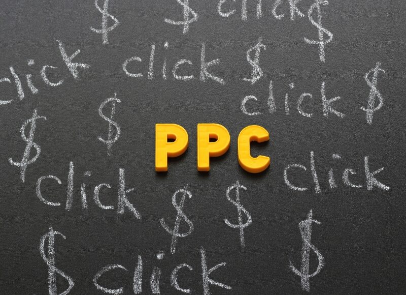 google ppc expert planning pay per click strategy with dollar signs and clicks drawn on blackboard