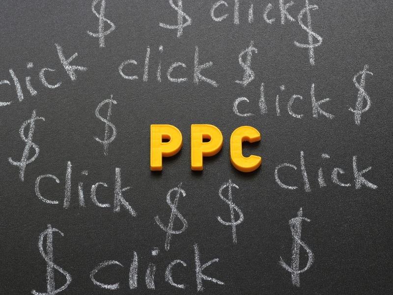google ppc expert planning pay per click strategy with dollar signs and clicks drawn on blackboard