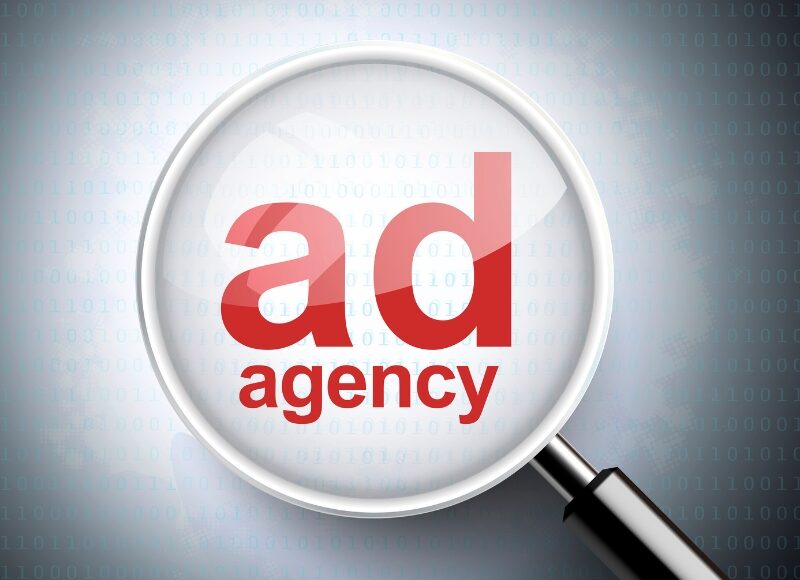 Magnifying glass showing ad agency concept linked to google ads agency for small business.