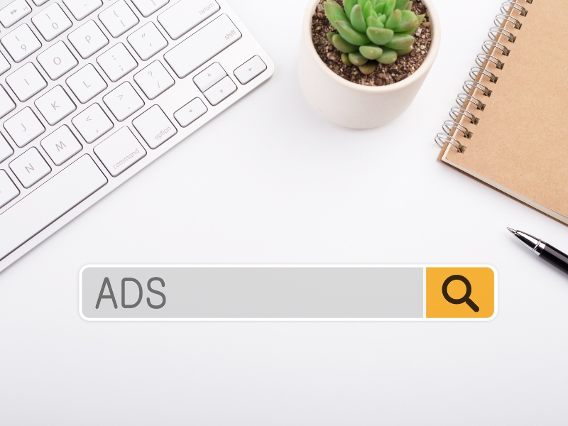 google ads management penrith search bar concept with keyboard, notebook, and plant on desk.