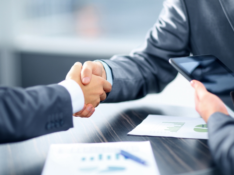 Two business professionals shaking hands after agreeing on a strategy to advertise Google Shopping for ecommerce growth.