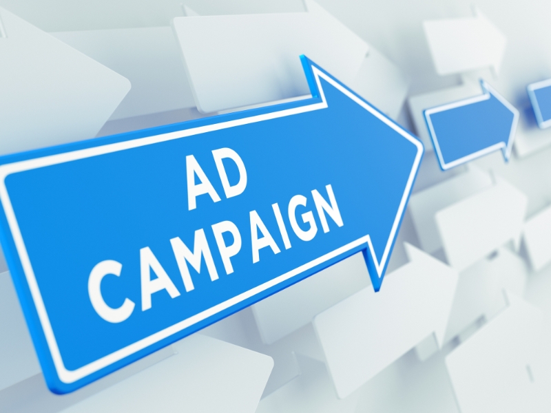Blue arrow sign pointing right with the words “Ad Campaign”, representing a google ads specialist strategy.