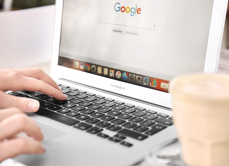 Person using a laptop with Google search open, showing a google ads specialist working online.