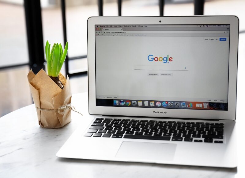 Laptop displaying Google search homepage, representing campaign management with Google Ads Assistant.