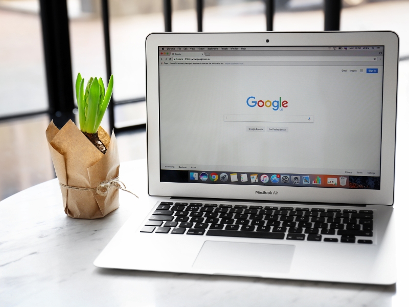 Laptop displaying Google search homepage, representing campaign management with Google Ads Assistant.