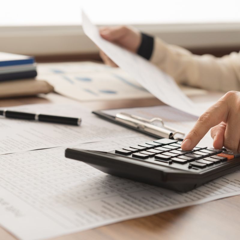 Digital Marketing For Accountants – hand using calculator in front of laptop for finance or accounting tasks.