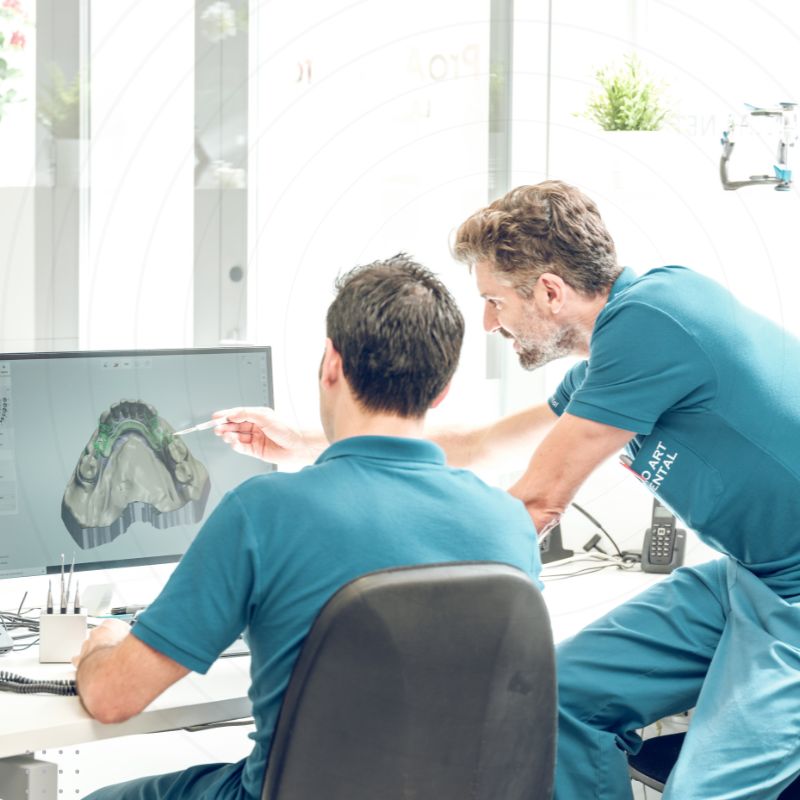 Two men reviewing an orthodontic practice strategy on a computer screen, highlighting effective digital marketing for orthodontists.