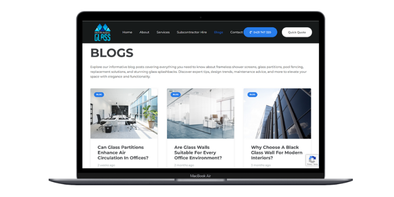 Laptop screen showing Intrinsic Glass blog page with office glass articles