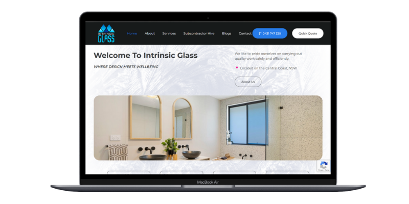 Laptop screen showing Intrinsic Glass welcome section and bathroom-style glass showcase