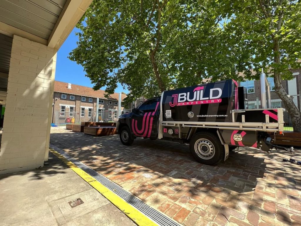 Branded JBuild Carpentry ute parked at a project site in daylight