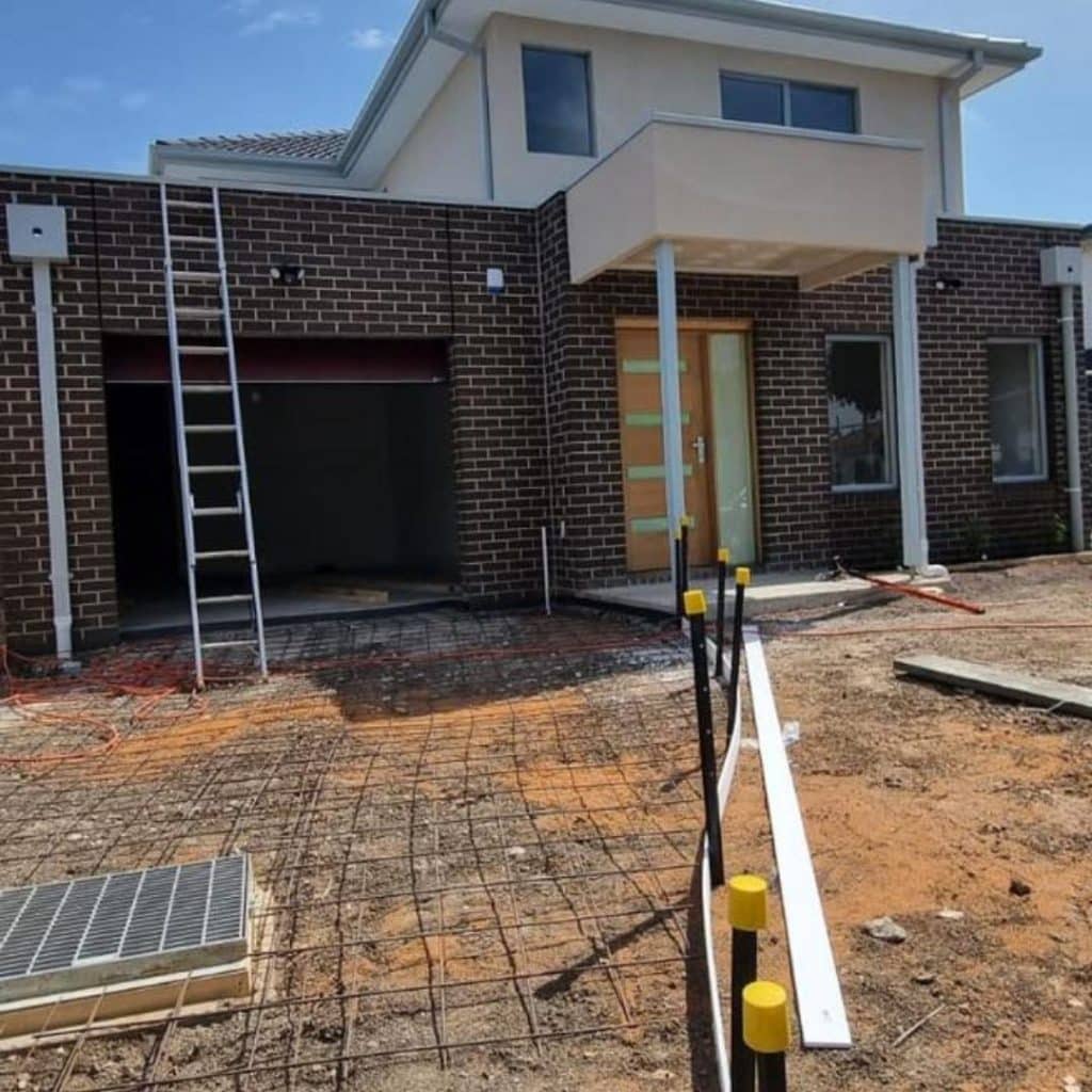 Residential property exterior during construction with driveway area ready for cleaning