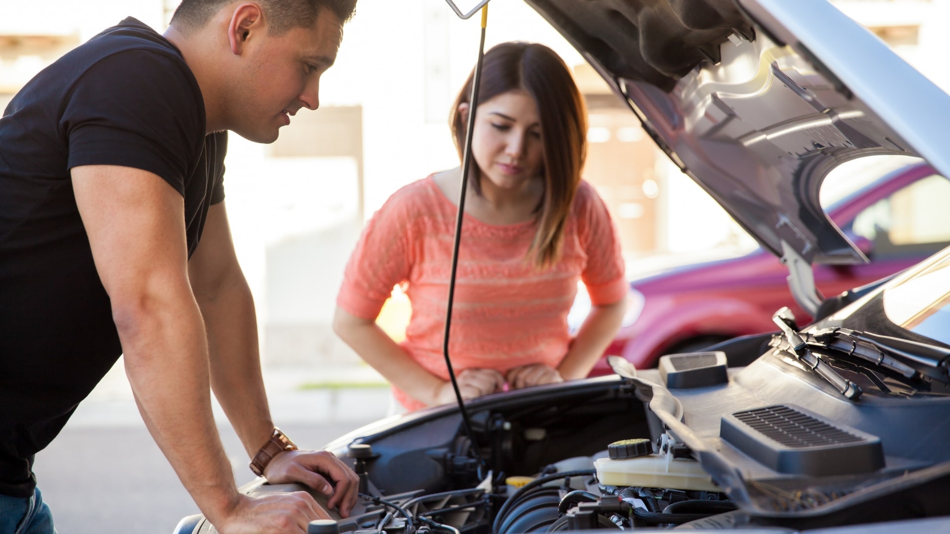 Driver and technician inspecting a car engine after a wrong fuel issue
